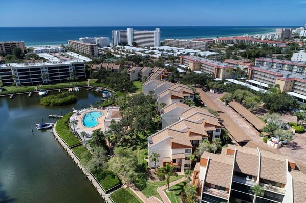 An aerial view of a resort with multiple buildings, a swimming pool, and a marina.
