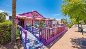 A vibrant building with a purple facade and a sign reading "The Fudge Factory." - Midnight Cove II 524D: 3-Bedroom Townhouse Steps from the Pool in Siesta Key (Siesta Key)