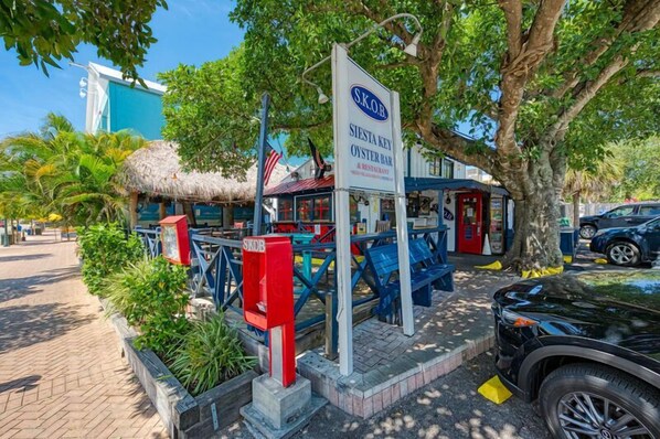 A seaside restaurant named 'Siesta Key Oyster Bar' with outdoor seating and a thatched-roof structure. - Midnight Cove II 524D: 3-Bedroom Townhouse Steps from the Pool in Siesta Key (Siesta Key)