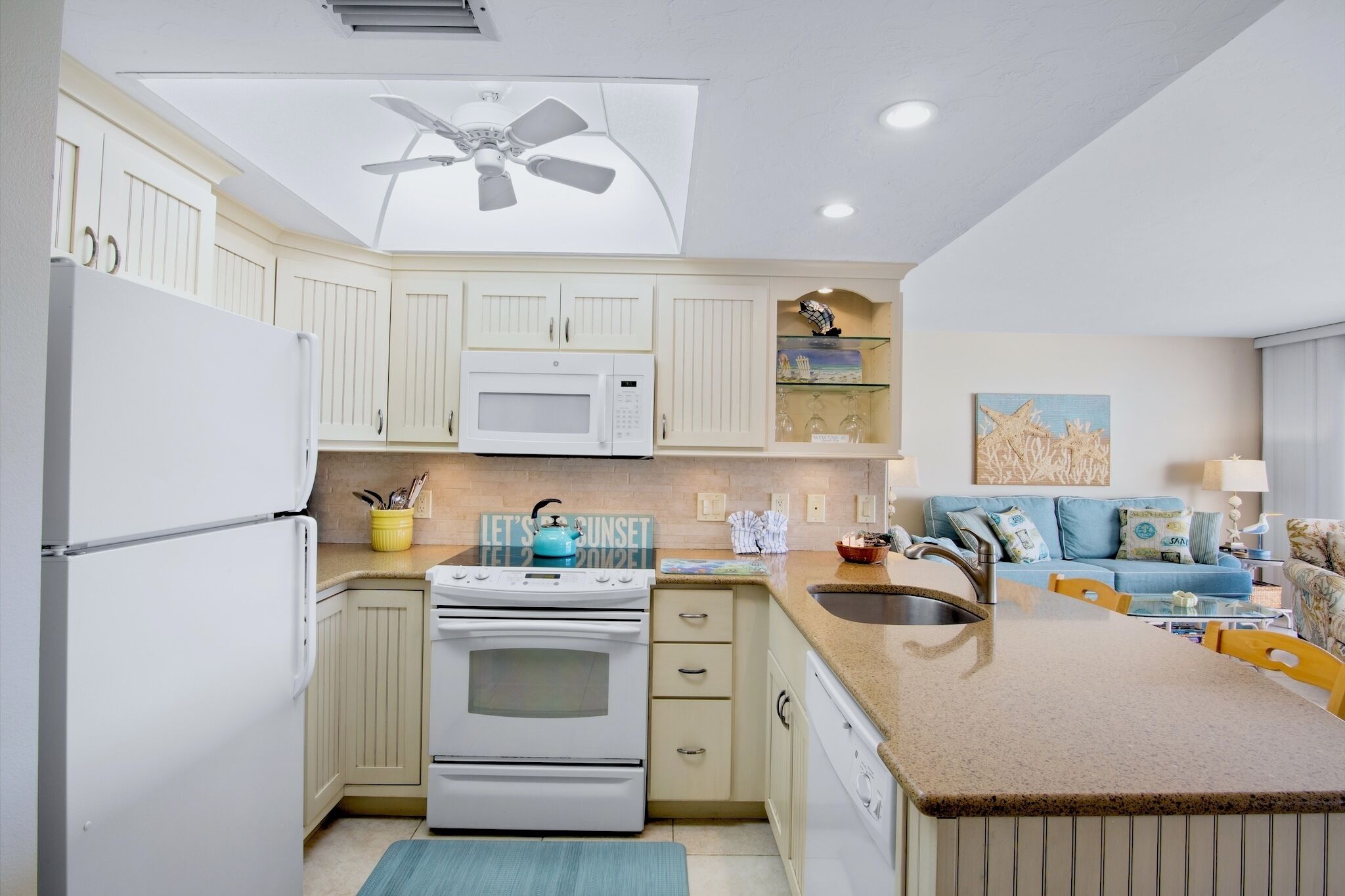 A modern kitchen with a built-in oven, microwave, and a ceiling fan.