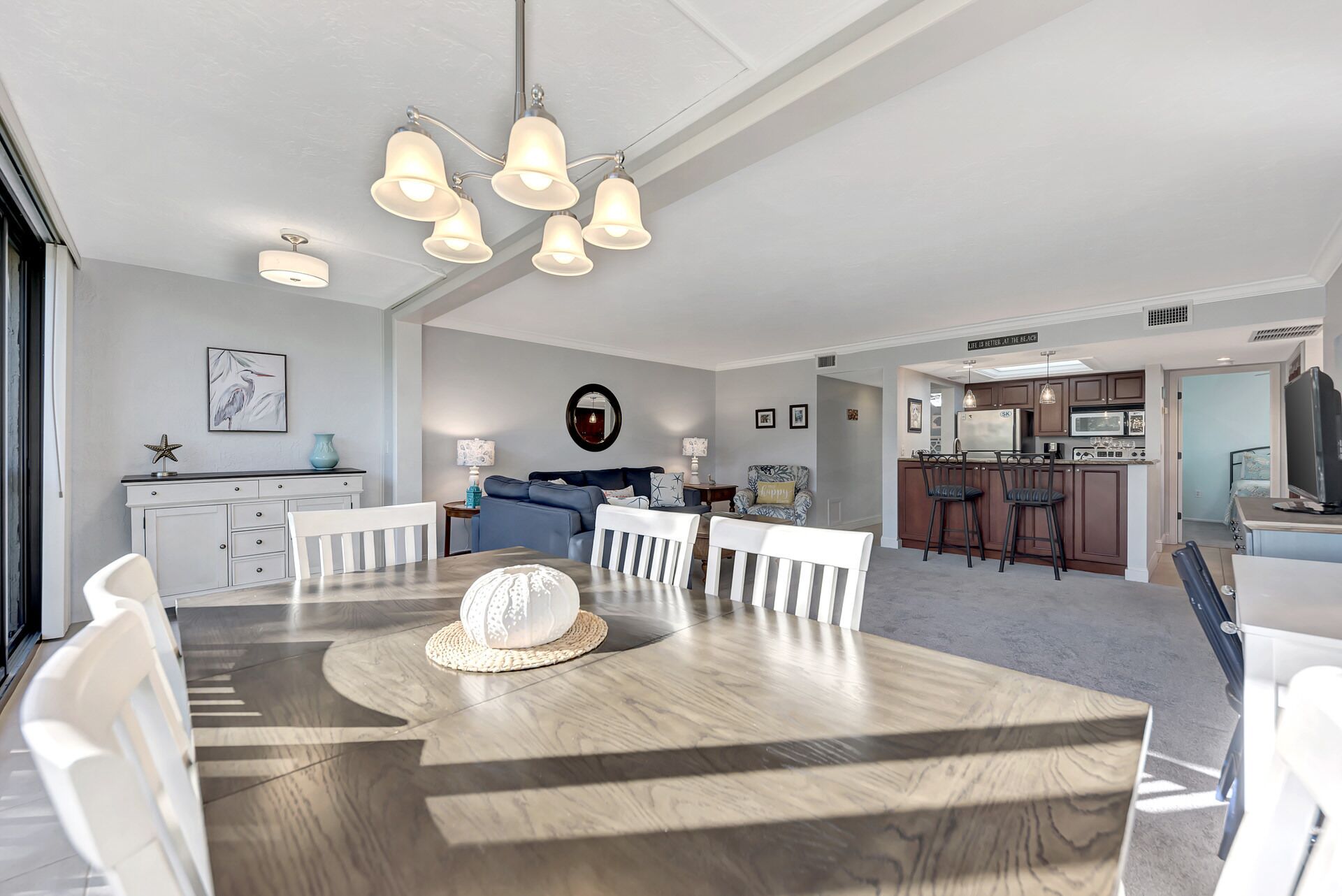 A modern kitchen with dark cabinets, a microwave, and a refrigerator.