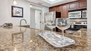 A kitchen with granite countertops, stainless steel appliances, and a skylight above the sink. - Midnight Cove II 820F - Updated Siesta Key Bayside Rental, Pool and Tennis Acces (Siesta Key)