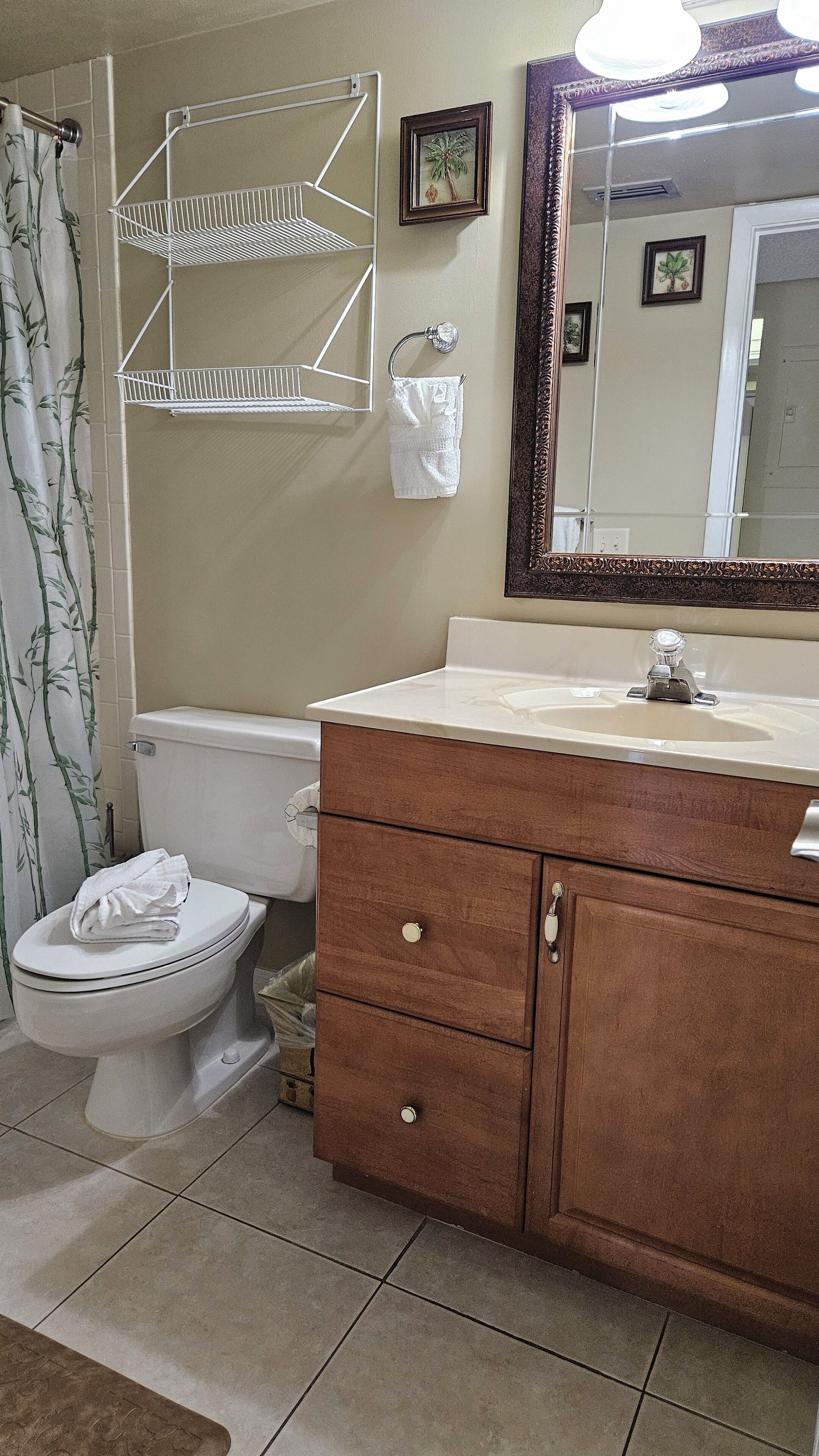 Ein Badezimmer mit Toilette, Waschbecken, Waschtisch und Spiegel.