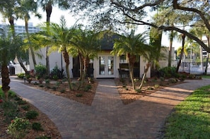 A pathway leading to a building with a white facade and a covered entrance.