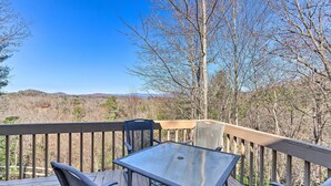 A wooden deck with a glass table and chairs, overlooking a forested landscape. - Murphy Cabin w/ Deck and Stunning Mountain Views (Murphy)