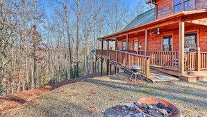 A cabin with a covered porch, a fire pit, and a gravel driveway surrounded by trees. - Murphy Cabin: Wheelchair Accessible w/ Fire Pit! (Murphy)