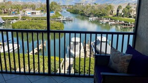 Ein Balkon mit Blick auf einen Fluss, angestellte Boote und eine Reihe von Häusern.