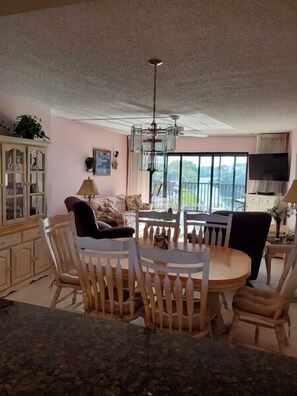 Enjoy meals in this stylish dining area with a round table and six chairs, a flat-screen TV, and a large window offering a view of the outdoors.