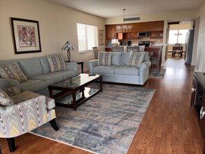 A spacious living room with a sofa, a coffee table, and a patterned rug.