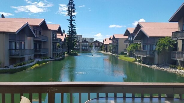 Un resort con una fuente central, edificios de varios pisos y cielo despejado.