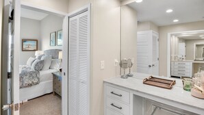 A bedroom with a bed, bedside table, and a closet. - Our House at the Beach C-214 Quiet Location, newly updated (Siesta Key)