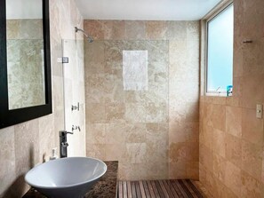 Un bagno moderno con una vasca da bagno freestanding, una cabina doccia in vetro e un ampio specchio.