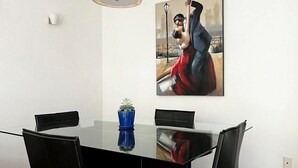A dining area with a glass table, black chairs, and a blue vase. - Condesa Residence Amsterdam 202 - Hipodromo area (Ciudad de México)