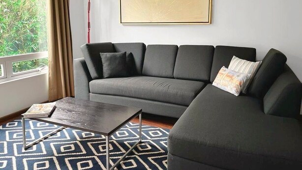 A modern living room with a grey sofa, a patterned rug, a framed artwork on the wall, and a red floor lamp. - Condesa Residence Amsterdam 202 - Hipodromo area (Ciudad de México)
