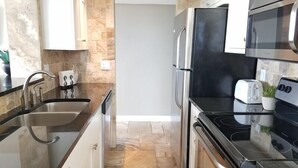 Een moderne keuken met roestvrijstalen apparatuur, een dubbele spoelbak en een broodrooster.