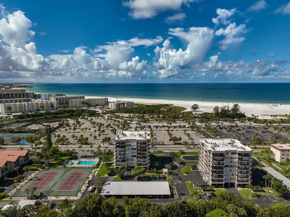 Un quartier résidentiel situé sur la côte, avec des propriétés donnant sur la plage, un court de tennis et une piscine.