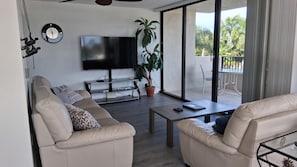 Een moderne woonkamer met een bank, salontafel en een flatscreen televisie.