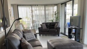 Uma sala de estar moderna com sofá, mesa de centro e televisão.