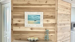 A rustic wooden desk with drawers and a shelf, a framed picture on the wall, and a small blue stool. - Our House at the Beach W-602 Beautiful Beach View! (Siesta Key)