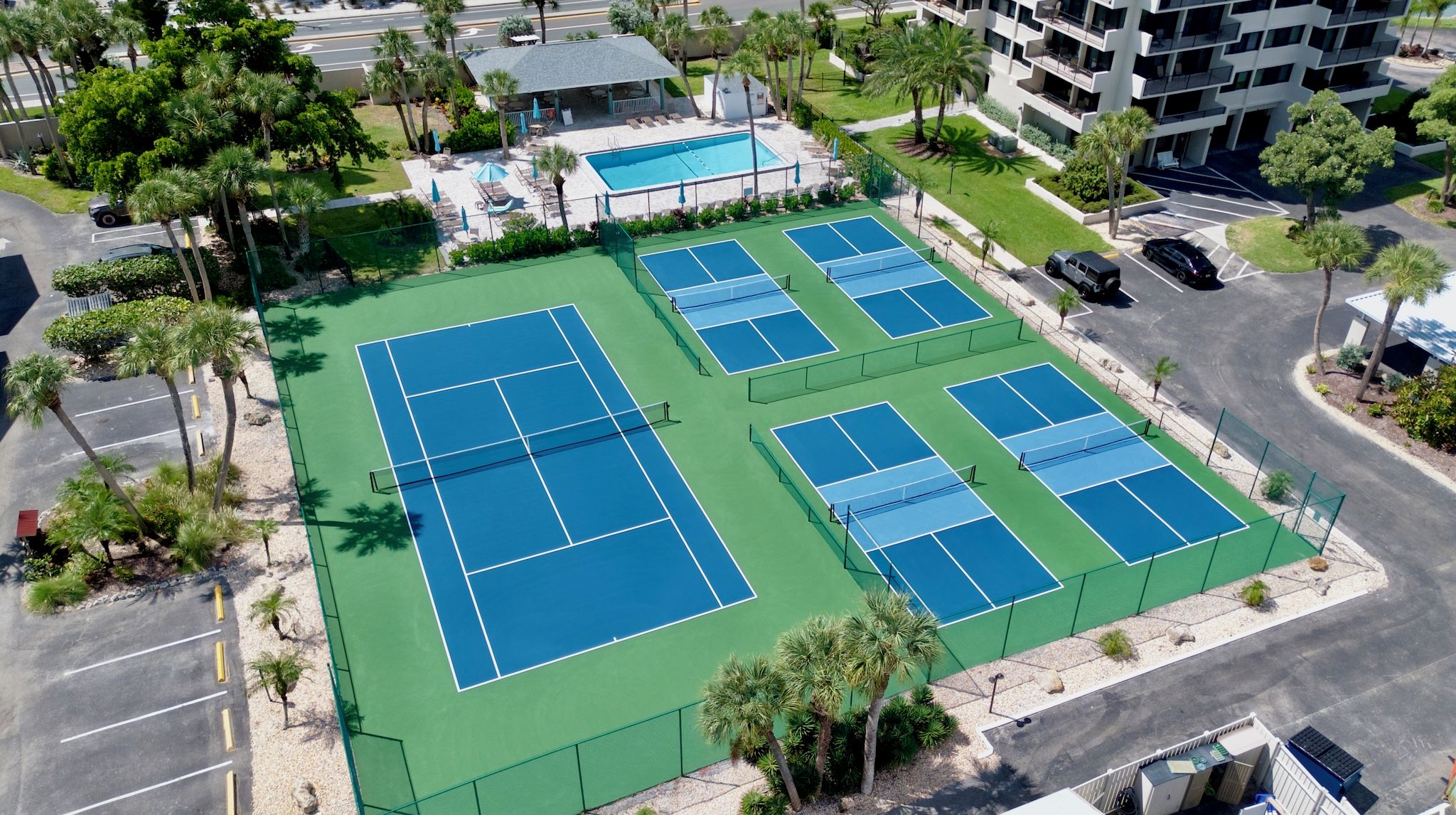 A multi-level parking structure with a tennis court complex.