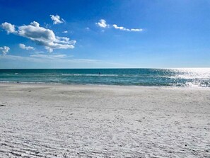 Una playa con cielo despejado y mar tranquilo.