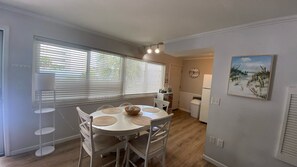 A dining area with a round table, chairs, and a white floor lamp.