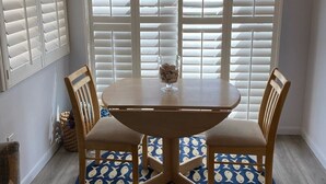 A dining area with a round table, two chairs, a vase with stones, and a patterned rug. - Townhouse with Beach Access, Shared Pool - Siesta Beach House 308 (Siesta Key)