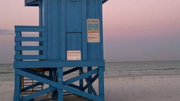 A blue lifeguard tower on a beach with a clear sky and a visible moon. - Sunset Royale - 100- Outdoor Patio directly across from Siesta Key Beach (Siesta Key)