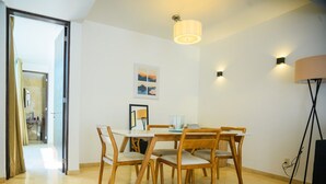 Ein Essbereich mit Tisch, Stühlen, einer Lampe und einem Bild an der Wand.