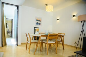 Un'area pranzo con tavolo e sedie, una lampada e un quadro appeso al muro.