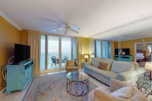 Relax on the spacious balcony with a view of the surroundings, featuring a comfortable sofa, armchair, and glass coffee table.
