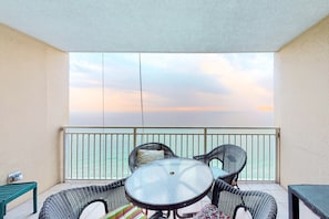 Enjoy a comfortable seating area with wicker chairs and a round table, offering a view of the sea.