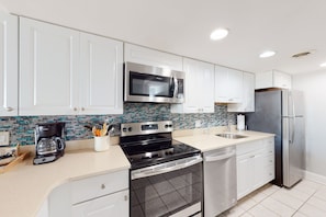 Enjoy cooking in this well-equipped kitchen with a microwave, oven, refrigerator, dishwasher, and coffee maker.