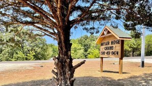 A wooden cabin sign with the text "ANTLER RIDGE CABINS 580 451 0474". - Antler Ridge Cabin #4 (Sulphur)
