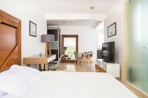 Camera d'albergo con letto, scrivania, sedia, televisione e vista sull'esterno.