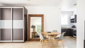 A modern kitchen with a dining area, a large cabinet, and a view of the outdoors. - Condesa Residence Amsterdam G (CDMX)