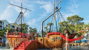 Ett piratskepp gjort av trä, med en röd trappa och ett nät som räcke.