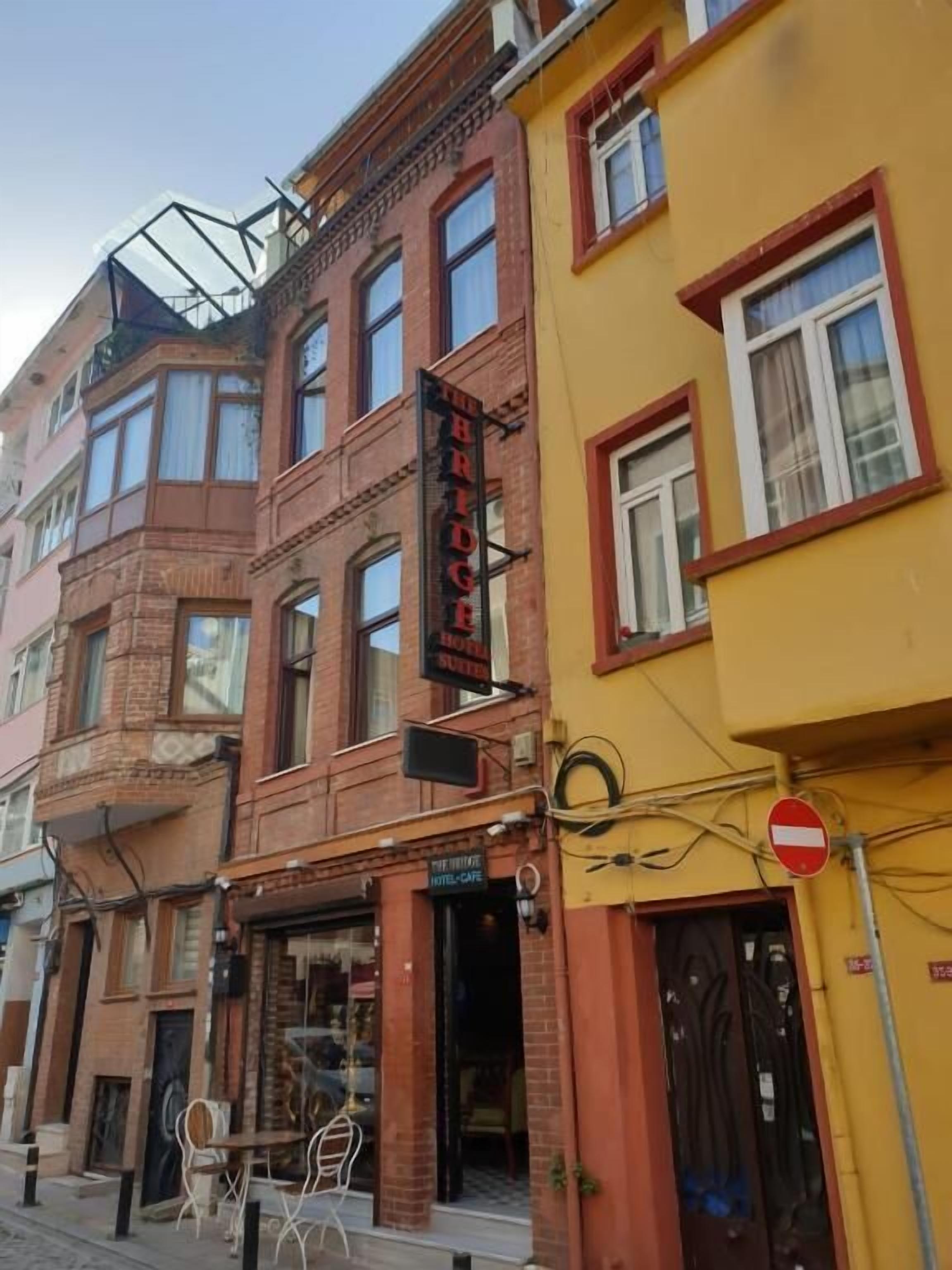 A hotel with a red brick facade, a yellow building next to it, and a 'No Entry' sign.