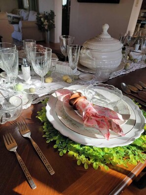 A dining table set with clear glassware, a white ceramic tureen, and a decorative centerpiece. - Amor Vida — a quiet 1910 farmhouse in the Colorado countryside (Ault)