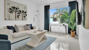 Ein modernes Wohnzimmer mit einer Couch, einem Couchtisch und einem Essbereich mit einem Stuhl und Tisch.