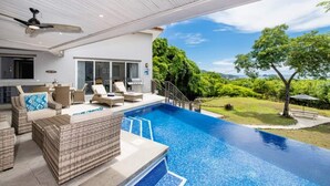 A modern house with a swimming pool, outdoor furniture, and a view of the surrounding greenery. - Amigos de Tortuga • 4 BR Villa • Private Pool • Oceanview (Playa Hermosa)