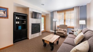 A living room with a fireplace, a television, a sofa, and a coffee table. - Premium Unit 1108 - One Bedroom - Zephyr Mountain Lodge 1 Condo (Winter Park)