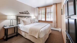 A neatly arranged bedroom with a bed, bedside table, lamp, and a window with curtains. - Premium Unit 1108 - One Bedroom - Zephyr Mountain Lodge 1 Condo (Winter Park)