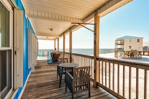 Enjoy the ocean view from this deck with a table and chairs, surrounded by a railing and a covered area.