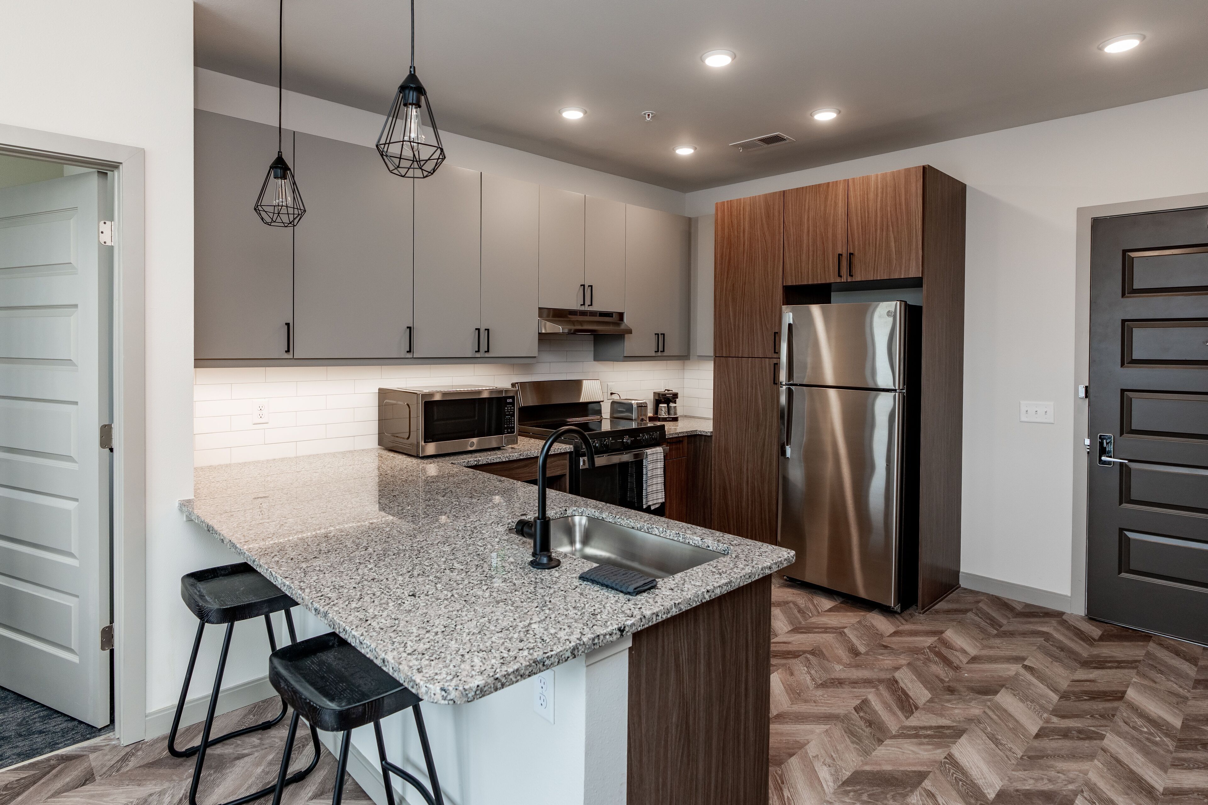 A modern kitchen with granite countertops, stainless steel appliances, and wooden cabinets.