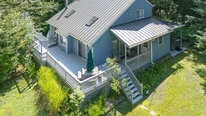 A two-story house with a porch, a covered deck, and a chimney.