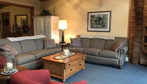 A living room with a sectional sofa, a wooden coffee table, and a lamp. - Belleayre Mountain Views (Pine Hill)
