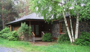 A rustic cabin with a stone exterior, wooden deck, and a small porch. - Belleayre Mountain Views (Pine Hill)