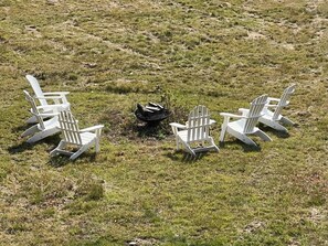 Four white Adirondack chairs arranged in a semi-circle around a central black object on a grassy field. - Belleayre Mountain Views (Pine Hill)
