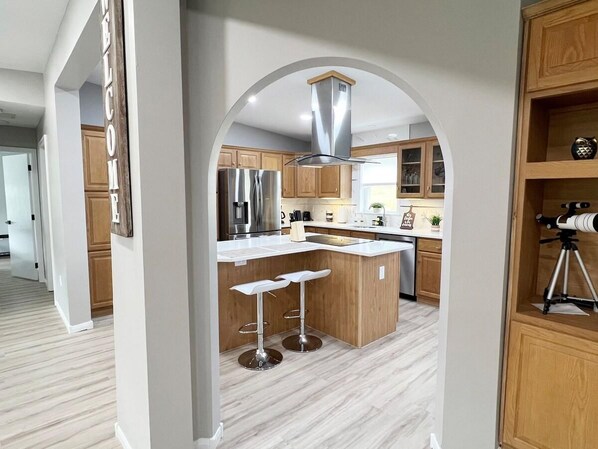 A modern kitchen with a central island, stainless steel appliances, and wooden cabinetry. - Escape to Serenity: 18-Acre Catskill Retreat (Margaretville)